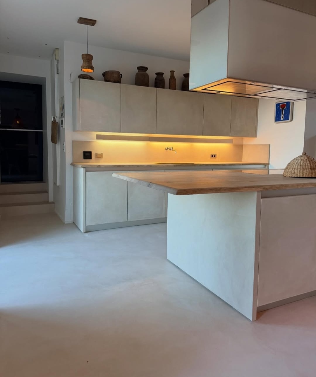 Sol et plan de travail en béton ciré dans une cuisine lumineuse Sol et plan de travail en béton ciré dans une cuisine lumineuse